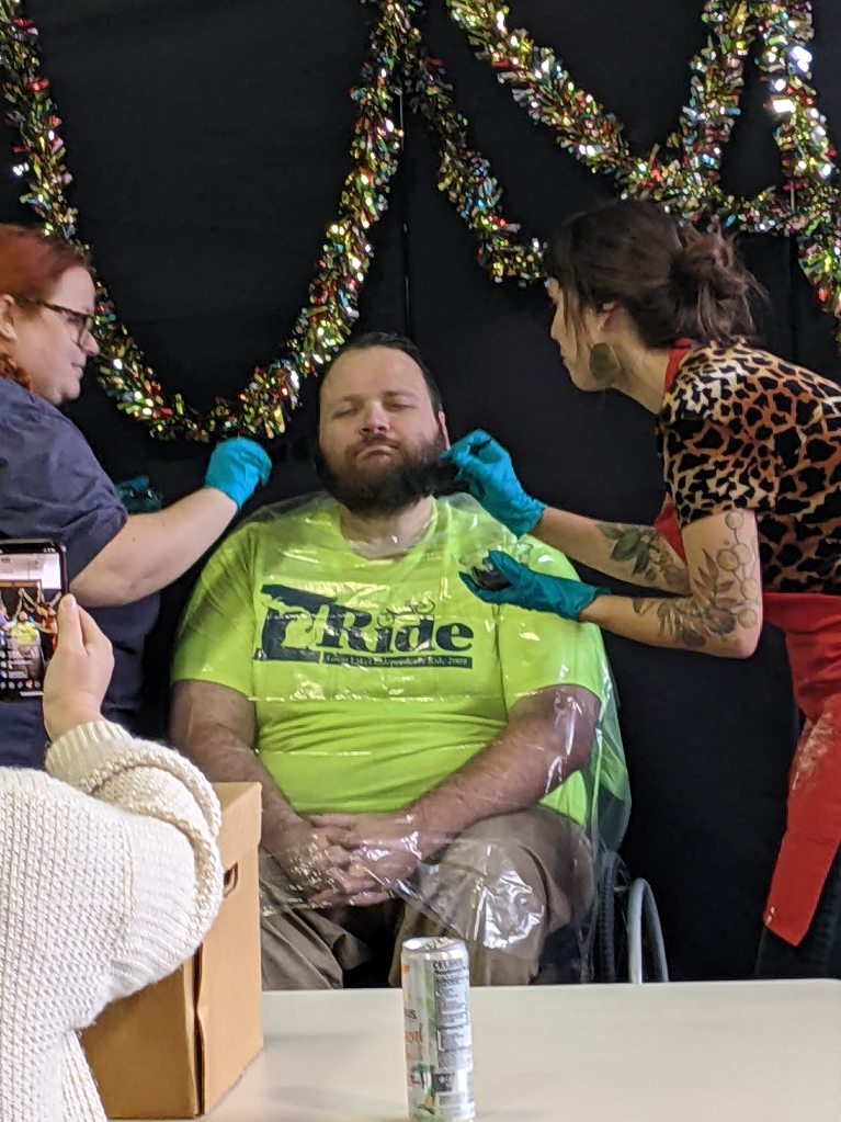 Krystina and Claire dyeing Alex's beard.